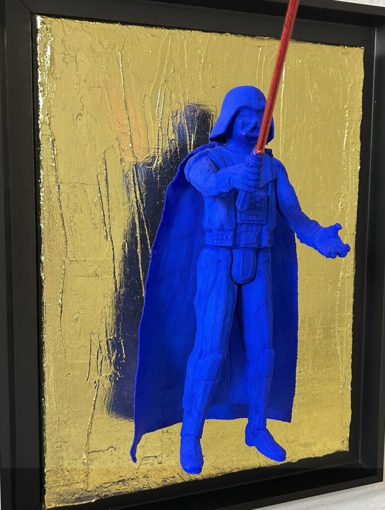 Contemporary pop art sculpture of a blue armored dark figure with red light sword on gold textured background, inspired by iconic sci-fi villain archetypes