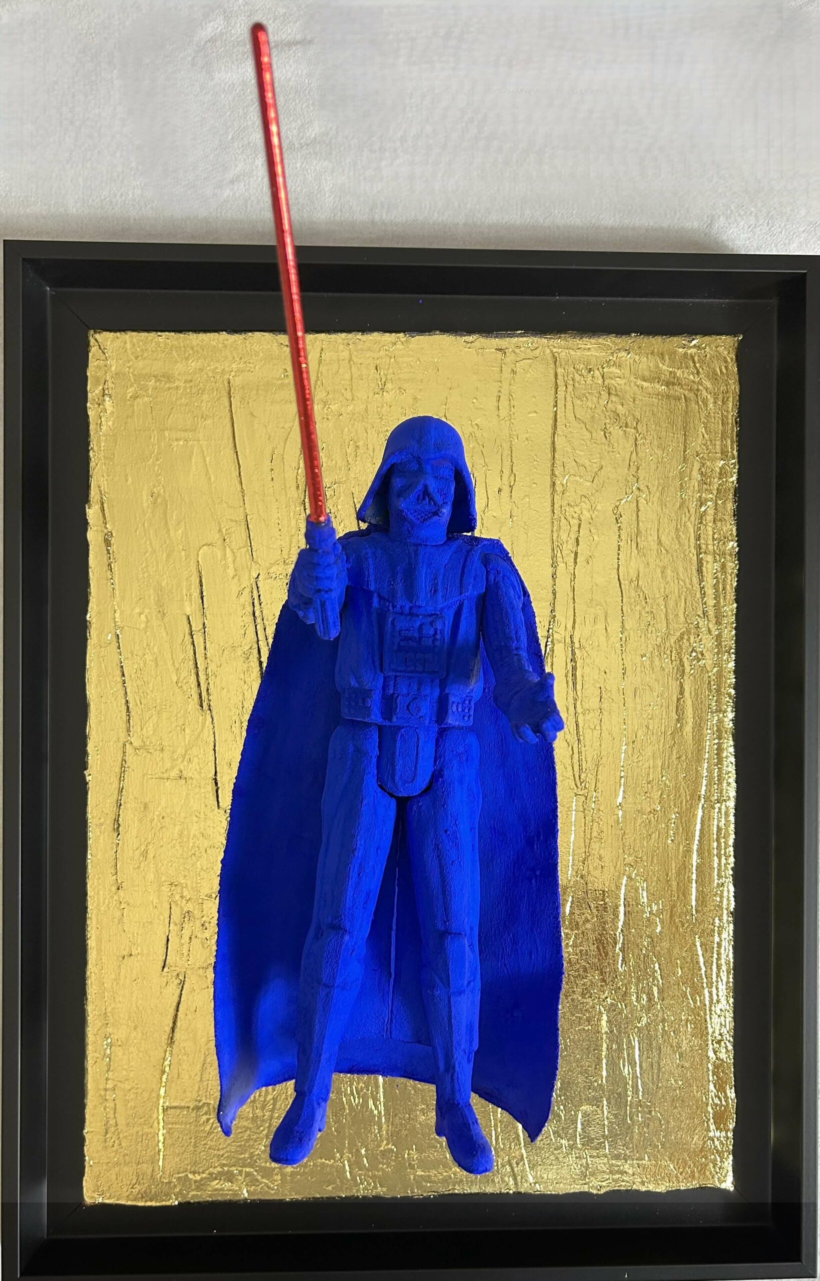 Seb Machten Contemporary pop art sculpture of a blue armored dark figure with red light sword on gold textured background, inspired by iconic sci-fi villain archetypes
