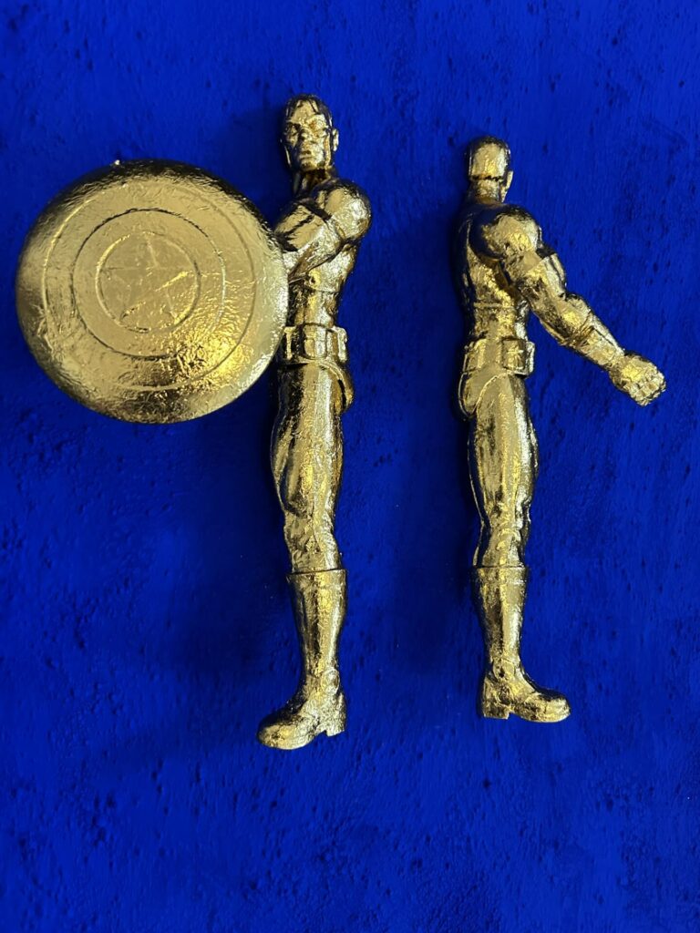 Seb Machten contemporary artwork with two gold superhero figures back to back on deep ultramarine surface