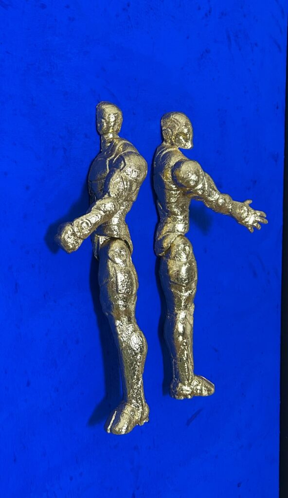 Seb Machten contemporary artwork with two gold superhero figures back to back on deep ultramarine surface