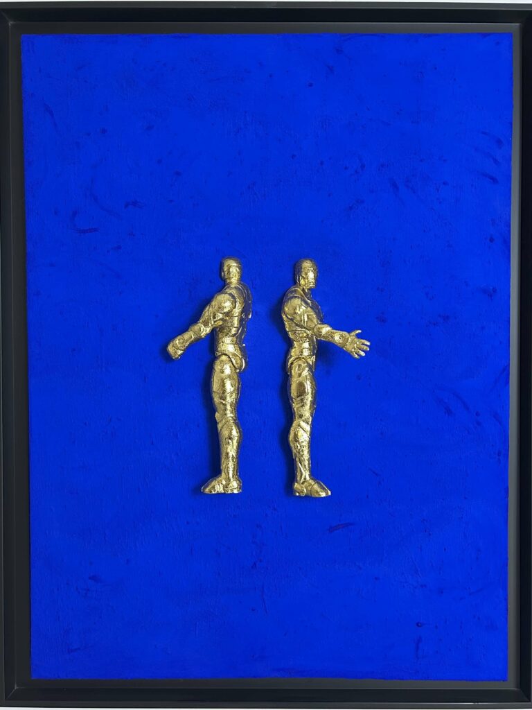 Seb Machten contemporary artwork with two gold superhero figures back to back on deep ultramarine surface