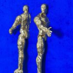 Seb Machten contemporary artwork with two gold superhero figures back to back on deep ultramarine surface