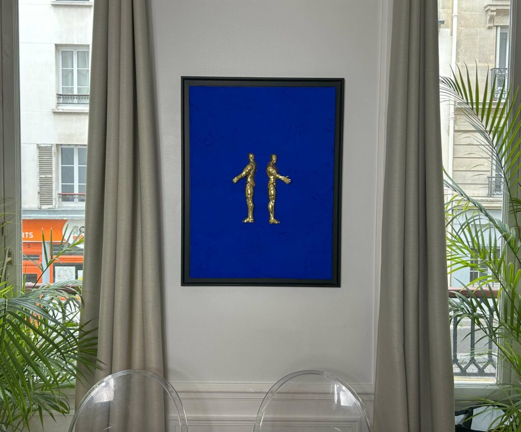 Seb Machten contemporary artwork with two gold superhero figures back to back on deep ultramarine surface