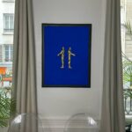 Seb Machten contemporary artwork with two gold superhero figures back to back on deep ultramarine surface