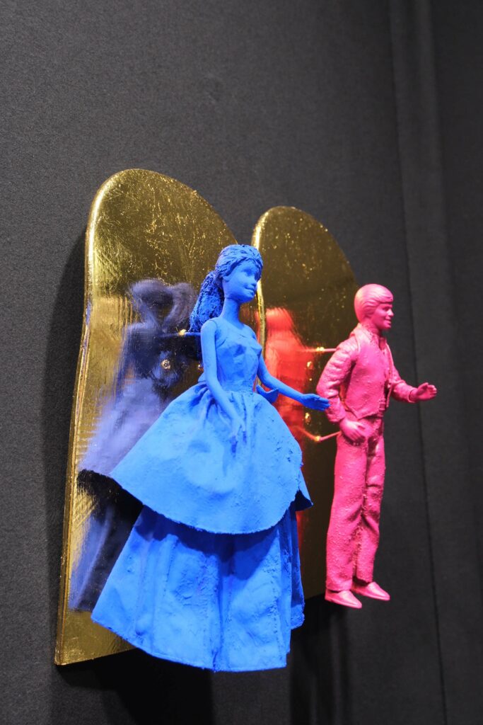 Seb Machten contemporary artwork with blue and pink doll figures on gold leaf skateboards