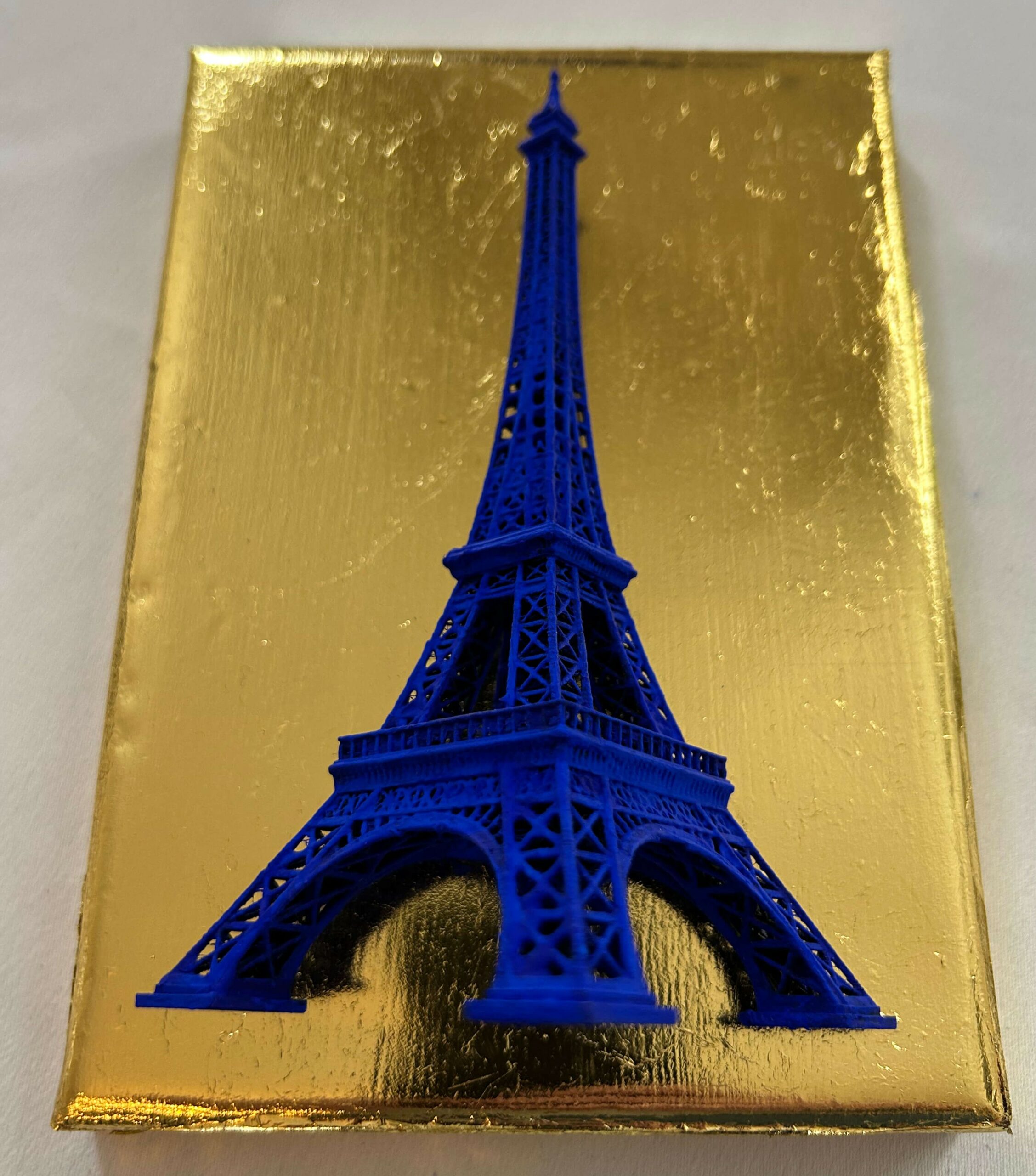 Seb Machten contemporary artwork with ultramarine Eiffel Tower sculpture on gold leaf surface