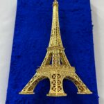 Seb Machten contemporary artwork with gold Eiffel Tower sculpture on deep ultramarine blue surface