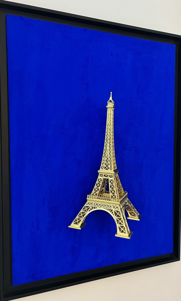 Seb Machten contemporary artwork with gold Eiffel Tower sculpture on deep ultramarine blue surface