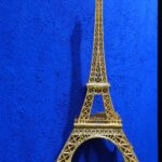 Seb Machten contemporary artwork with gold Eiffel Tower sculpture on deep ultramarine blue surface