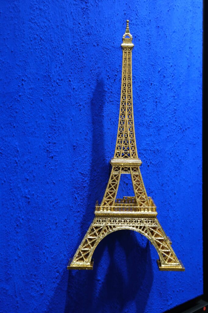 Seb Machten contemporary artwork with gold Eiffel Tower sculpture on deep ultramarine blue surface