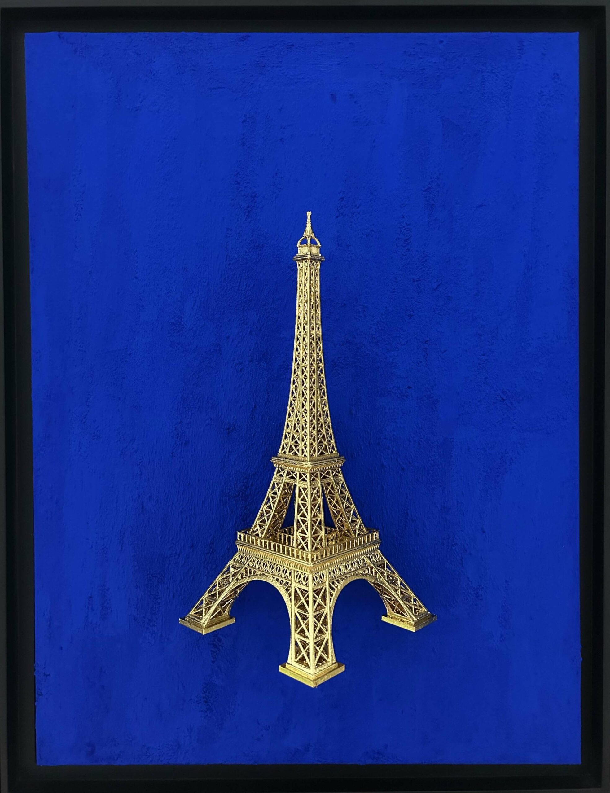 Seb Machten contemporary artwork with gold Eiffel Tower sculpture on deep ultramarine blue surface