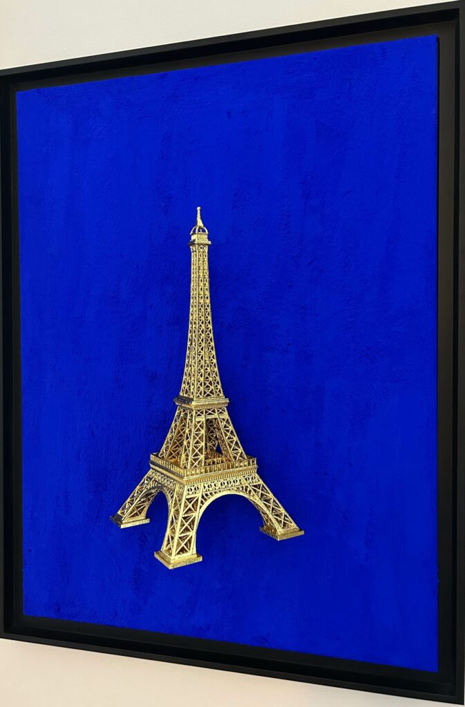 Seb Machten contemporary artwork with gold Eiffel Tower sculpture on deep ultramarine blue surface