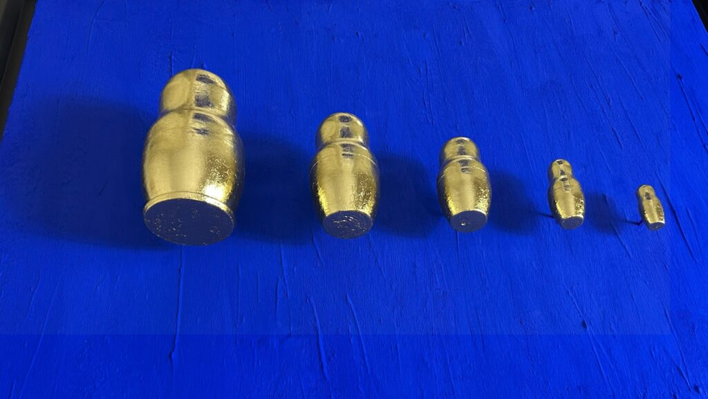 Seb Machten contemporary artwork with gold matryoshka figures evolving in size on deep ultramarine surface