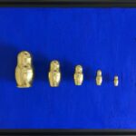 Seb Machten contemporary artwork with gold matryoshka figures evolving in size on deep ultramarine surface