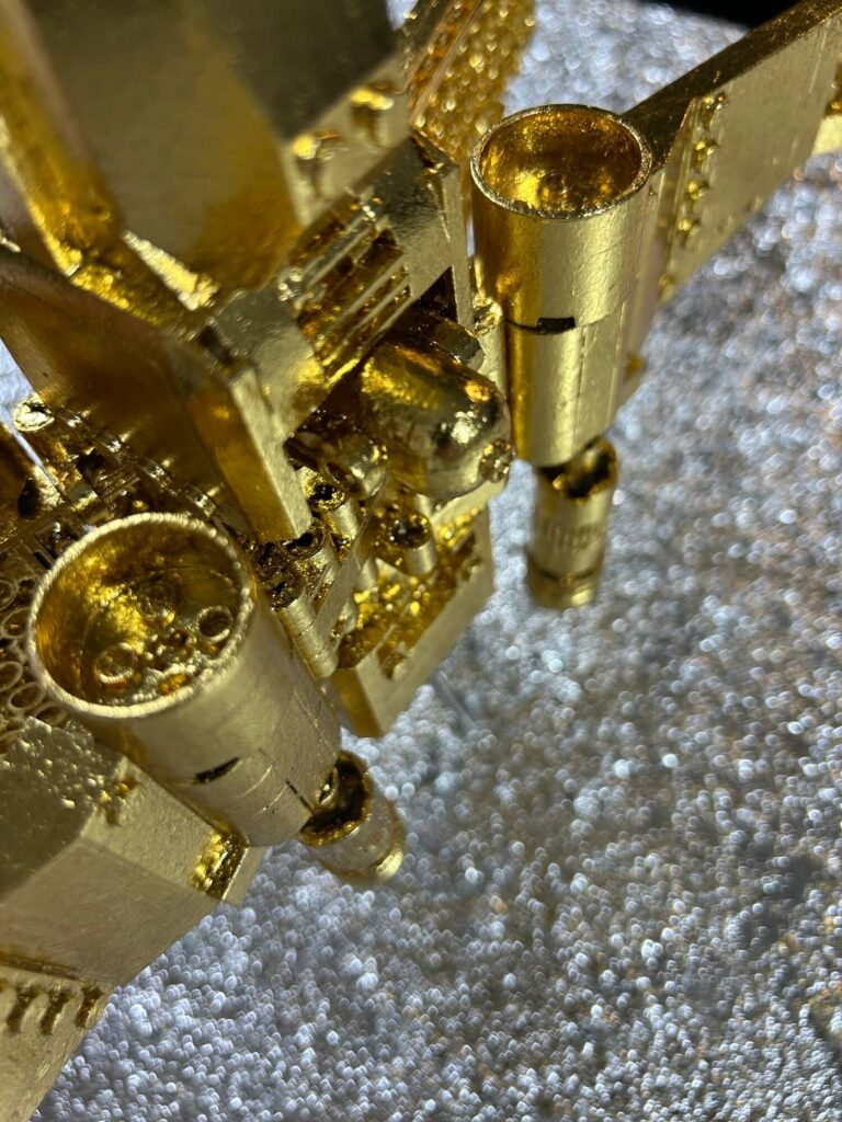 Seb Machten contemporary artwork with gold starfighter built from construction bricks emerging from lunar textured surface