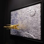 Seb Machten contemporary artwork with gold starfighter built from construction bricks emerging from lunar textured surface